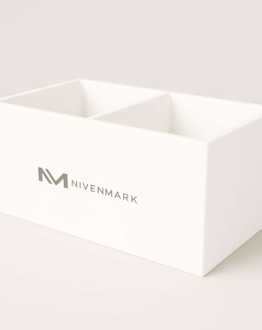 Logotipo Nivenmark impreso en negro sobre la cara de un organizador de escritorio de cartón rígido crema.